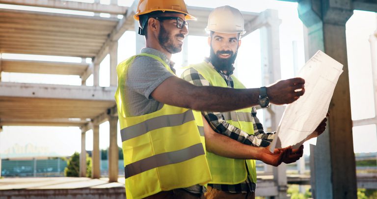 Construction engineers discussion with architects at construction site